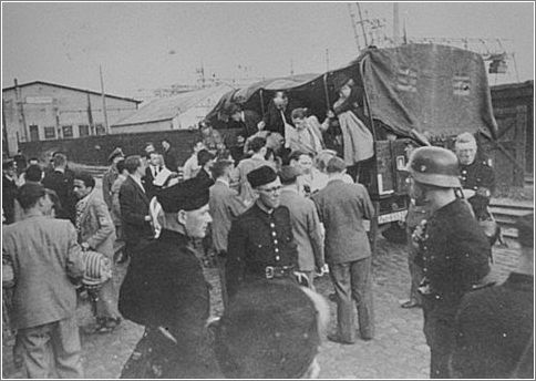 Jews seized in their homes are brought by truck to the Muiderpoort railroad station in the Polderweg district